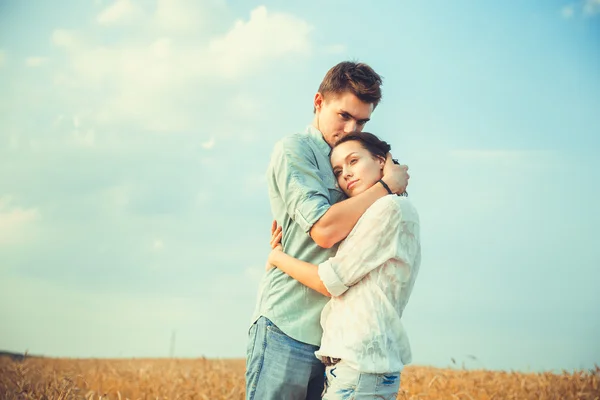 Young couple in love outdoor.Stunning sensual outdoor portrait of young stylish fashion couple posing in summer in field.Happy Smiling Couple in love.They are smiling and looking at each other