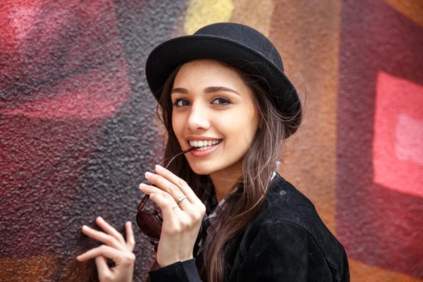 Smiling urban girl with smile on her face. Portrait of fashionable gir wearing a rock black style having fun outdoors in the city