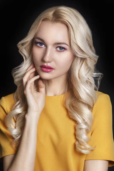 Beautiful woman with curly blond hair and evening make-up. Jewelry and Beauty. Fashion art photo. Pink make-up.
