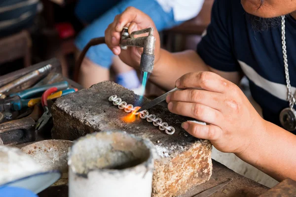Jeweler\'s hands while working making jewelry in Vientiane, Laos