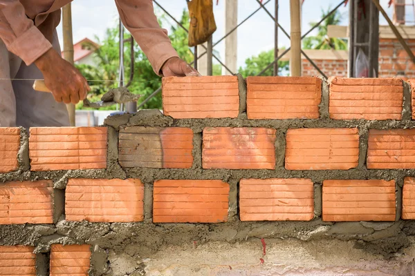 Builder laying bricks in site.