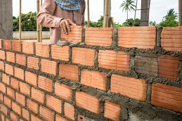 Builder laying bricks in site.
