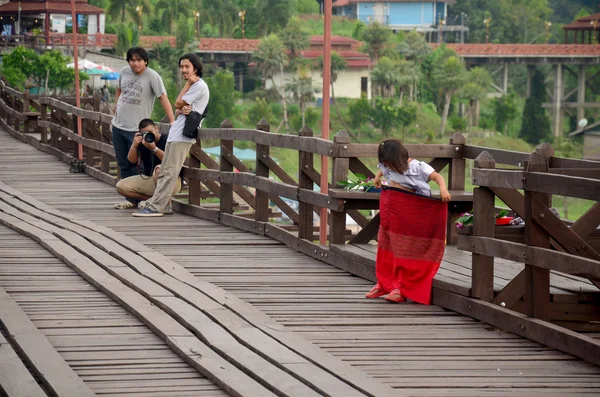 Burmese girl standing and play on Saphan Mon wooden bridge in mo