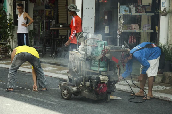 Thai man working mark line thermoplastic traffic routes on the r