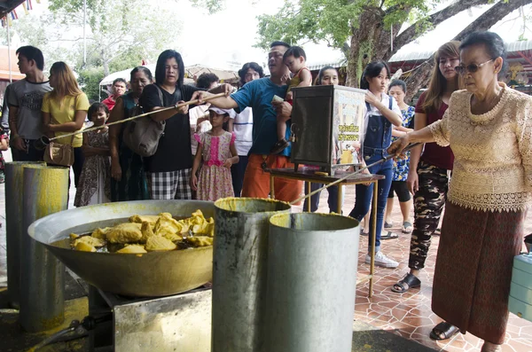 Thai people join melting cast candle offer to temple in traditio