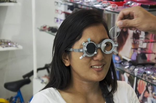 Thai woman check optical eye test or visual acuity for making gl