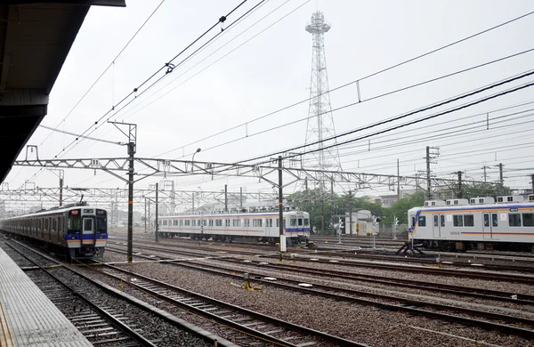 Trains stopping at Wakayama railway station while raining