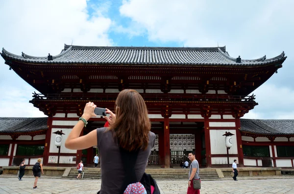 Traveler use smart phone shooting photo Todai-ji Temple