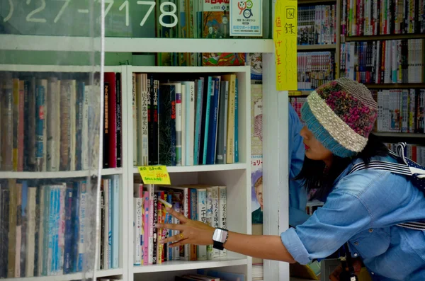 Thai women select and buy second hand book at Nara bookstore