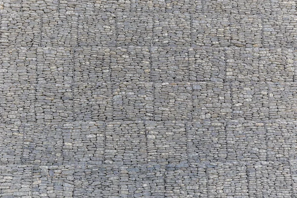 The wall of river stones packed in a metal grid