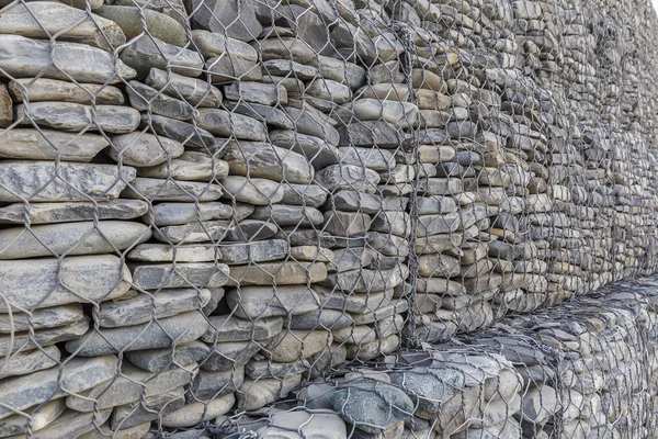 The wall of river stones packed in a metal grid