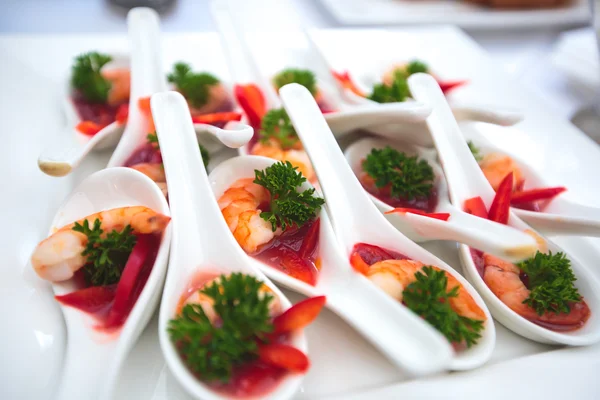 Beautifully decorated catering banquet table with different food snacks and appetizers with sandwich, caviar, fresh fruits on corporate christmas birthday party