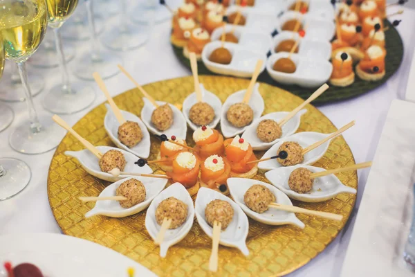 Beautifully decorated catering banquet table with different food snacks and appetizers with sandwich, caviar, fresh fruits on corporate christmas birthday party