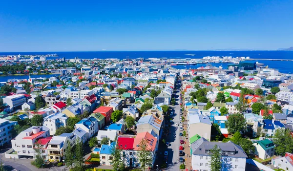 Beautiful super wide-angle aerial view of Reykjavik, Iceland with harbor and skyline mountains and scenery beyond the city, seen from the observation tower of Hallgrimskirkja Cathedral.