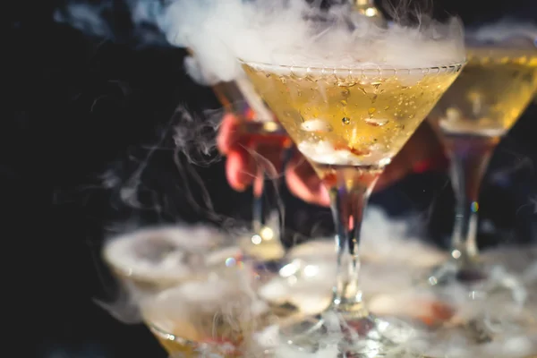 Beautiful row line of different colored alcohol cocktails with mint on a christmas party, martini, vodka,and others on decorated catering bouquet table on open air event