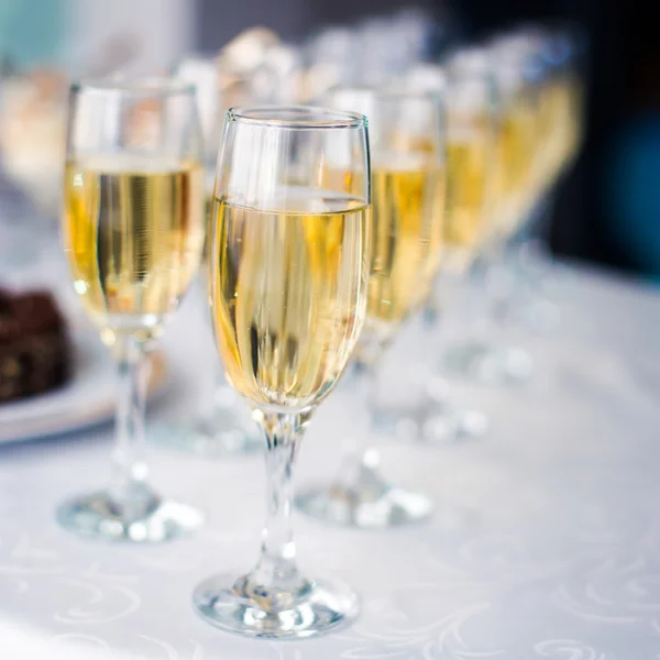 Beautiful row line of different colored alcohol cocktails with mint on a christmas party, martini, vodka,and others on decorated catering bouquet table on open air event, picture with beautiful bokeh