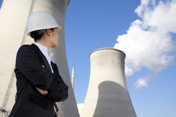 Engineer in front of cooling towers