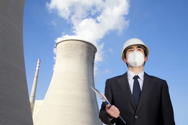 Businessman at power plant with face mask