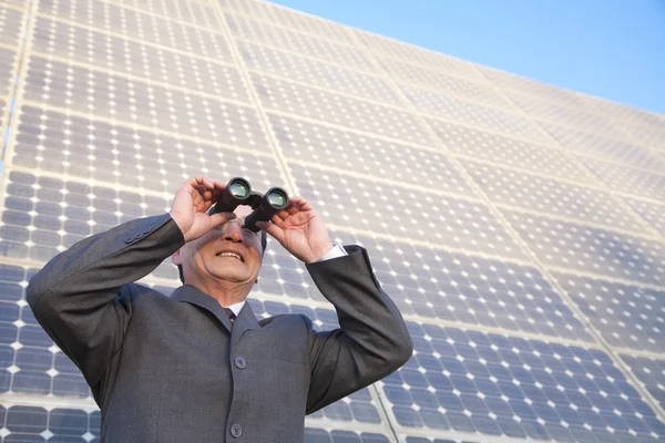 Businessman looking through binoculars