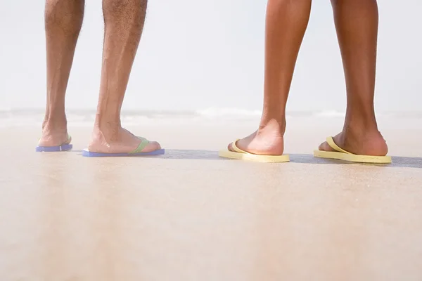 Two people standing on a beach