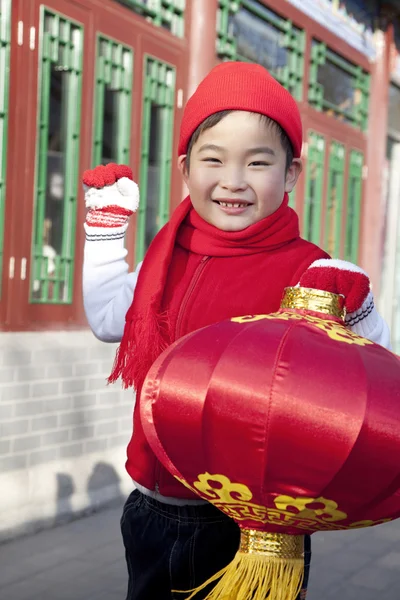 Boy holding red lantern in Courtyard