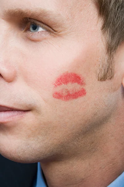 Man with lipstick kiss on cheek