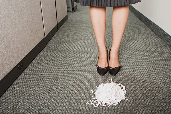 Businesswoman stood in front of pile of paper shreddings