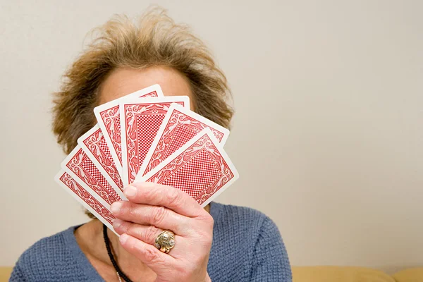 Senior woman holding playing cards