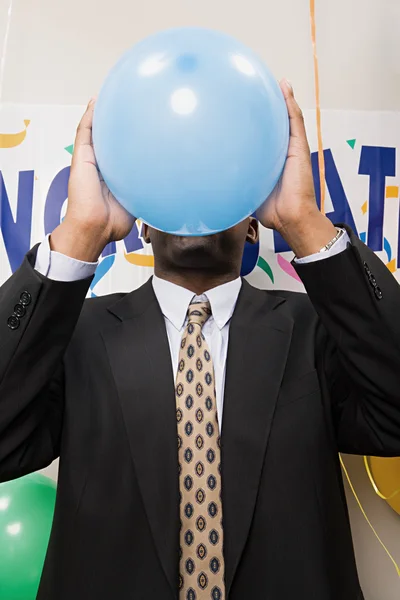 Businessman blowing up a balloon