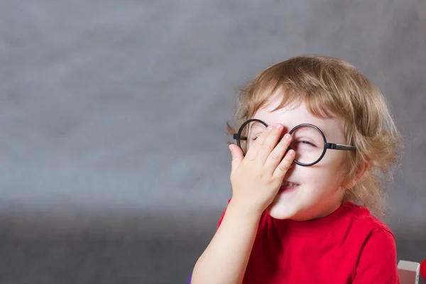 A child covers its face with a palm