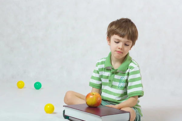 A boy observes the pile of books