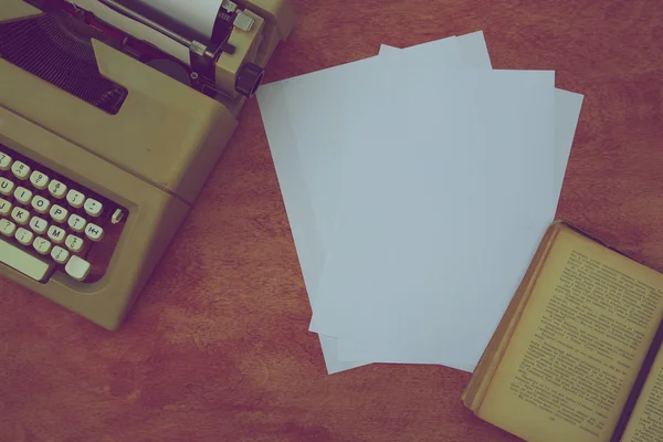 Old typing machine,old book in Russian,white sheets of paper