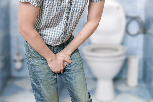 Man with prostate problem in front of toilet bowl. Incontinence