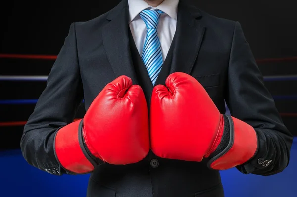 Boxing businessman with red gloves in box ring.