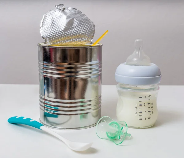Bottle with milk formula and can for feeding newborn.