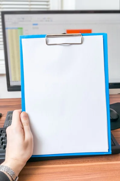 Hand of businessman is holding blank clipboard in office. Empty frame for custom message.