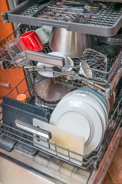 Dishwasher in kitchen and dirty dishes inside.