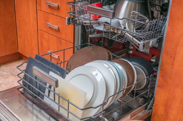 Dishwasher machine filled with dirty dishes.