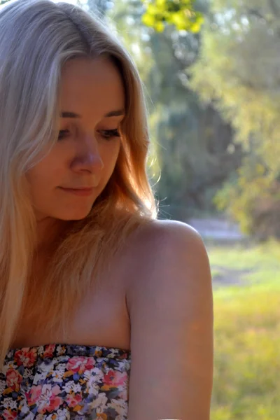 Young beautiful blond woman with long hair looking away and smiling gently