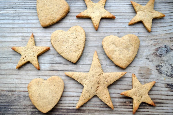 Gingerbread cookies in shapes of heart, star and man on wooden table