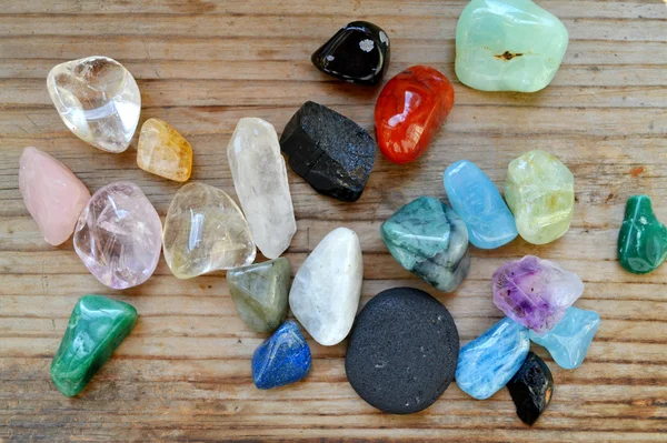 Different colourful gems on wooden table