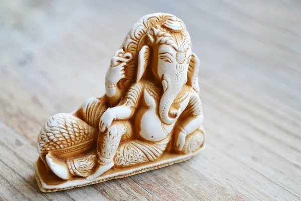 Indian god Ganesha (Ganapati) on wooden background