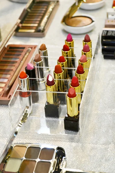 Set of colorful lipsticks with other cosmetics on a dressing table