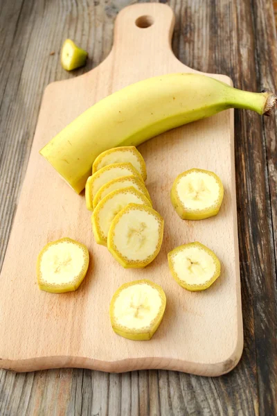 Yellow banana slices on wooden board