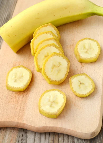 Yellow banana slices on wooden board