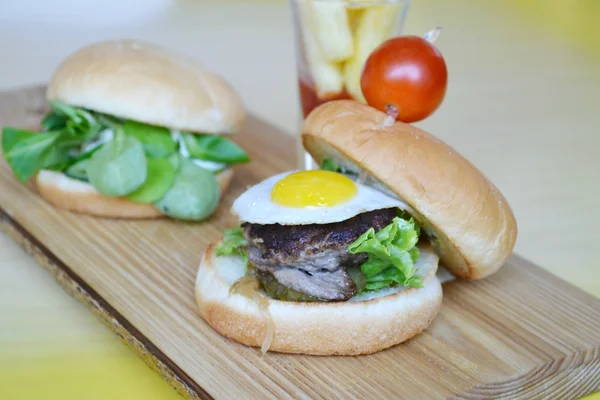 Two cute mini burgers with fried eggs