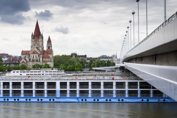 VIENNA, AUSTRIA - MAY 7: Cruise ship on Danube with St. Francis of Assisi Church on Mexikoplatz on 7 May 2012 in Vienna, Austria.