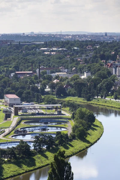 Aerial view of river meandering around sewage water treatment plant