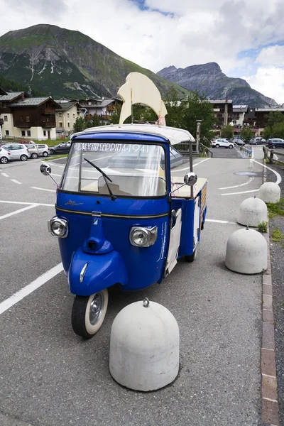 Limited edition model of three-wheeled vehicle Piaggio Ape Calessino stands on street on 1 August 2016 in Livigno, Italy.