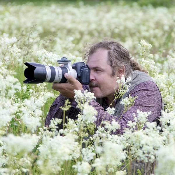 Photographer with camera on flower field